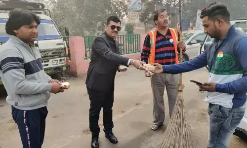 सफाई कर्मचारियों को मिठाई का पैकेट बांटते हुए नगर आयुक्त दिनेश चंद्र सिंह।