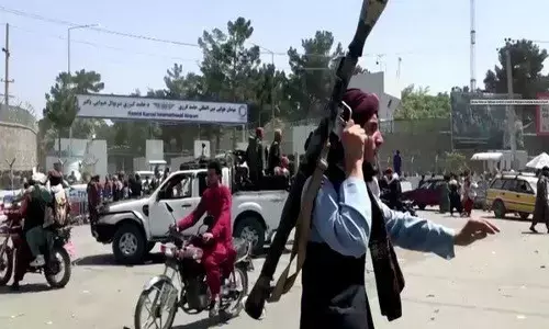 निराश होकर अफगान महिलाओं ने काबुल हवाई अड्डे के परिसर में बच्चों को रेजर के तार पर फेंका..