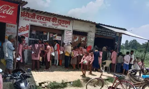 UP News : कंपोजिट विद्यालय खजुरहट के अध्ययनरत बच्चों को शराब ठेके के बगल में बांटा जाता है राशन