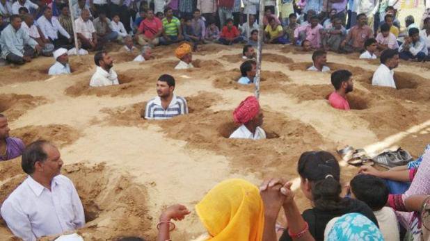 राजस्थान : खुद को गर्दन तक जमीन में गाड़ किसान ले रहे हैं जमीन समाधि