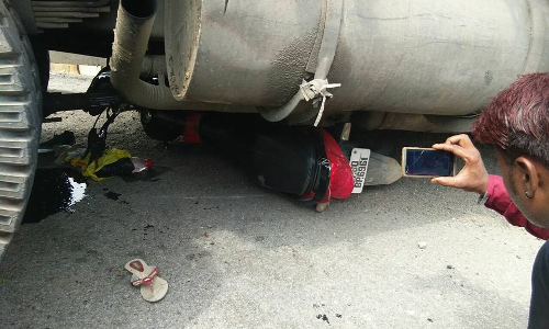 असंतुलित हुआ ट्रक रेलिंग तोड़ सडक पर गिरा, एक बाइक नीचे दबी, कुछ लोग दबे होने की आशंका