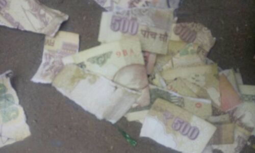 वाराणसी: नदेसर चुंगी के पास ओरियंटल बैंक ऑफ़ कामर्स के बाहर 500 और 1000 कटे फटे नोट फेंके