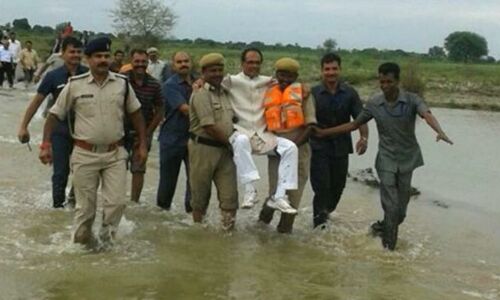 गोद में चढ़कर शिवराज ने किया बाढ़ निरीक्षण, तस्वीरें हुई वायरल